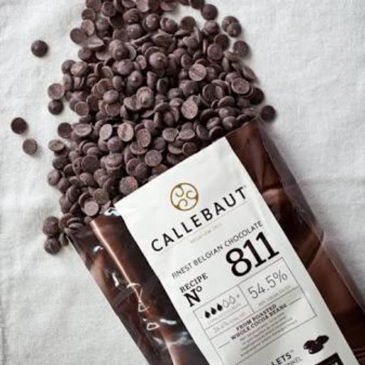 Callebaut chocolate bar with a scattering of chocolate chips on a light background