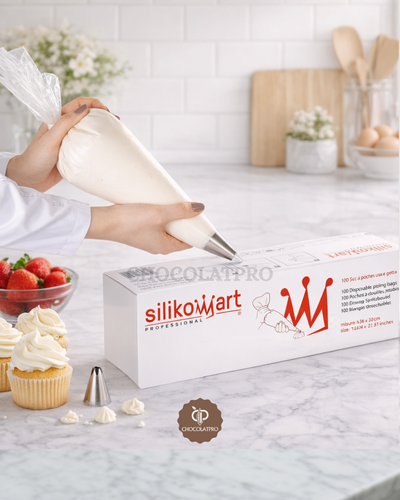 Silikomart professional piping bag set on a kitchen counter with cupcakes and strawberries.